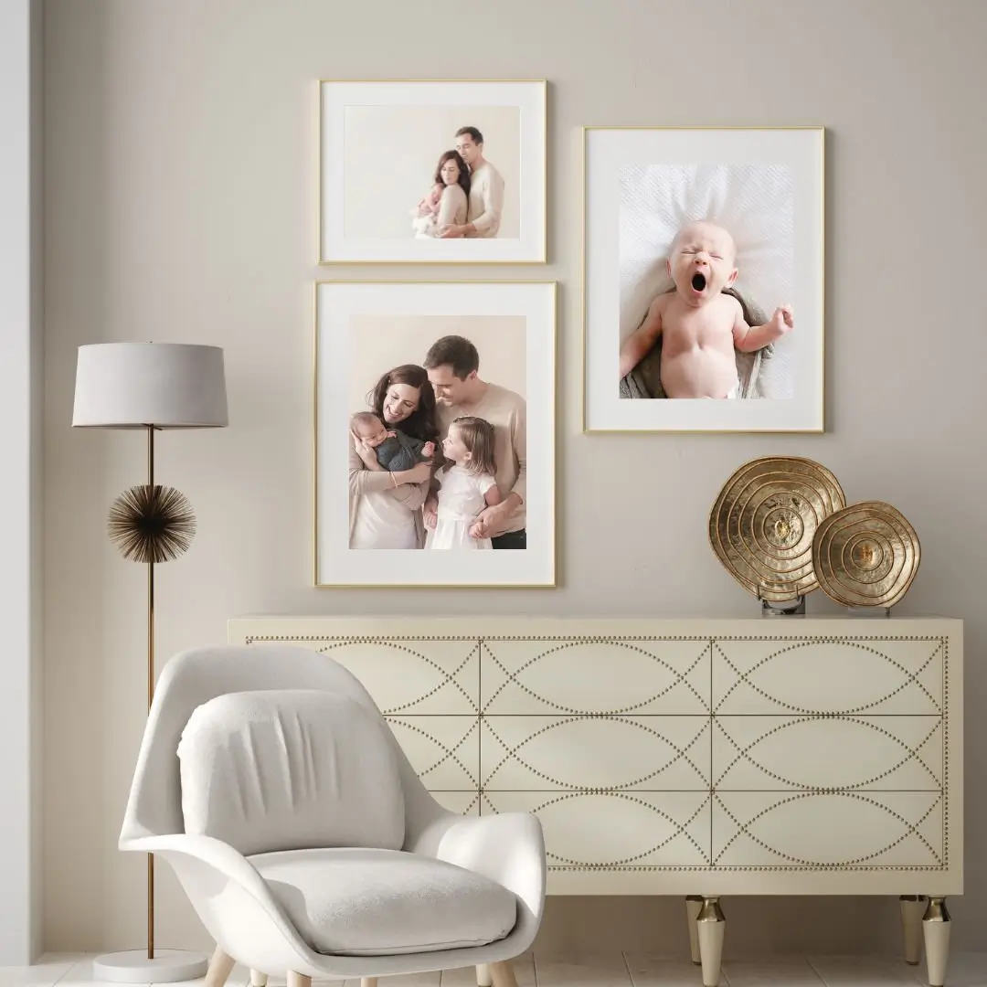 A modern living room with a white armchair, a decorative lamp, a cream sideboard with gold accents, and three family