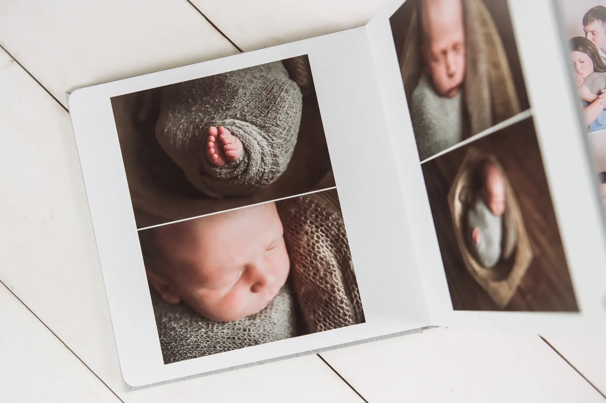 An open photo album by a Chicago Newborn Photographer displays close-up images of a newborn baby wrapped in a knit