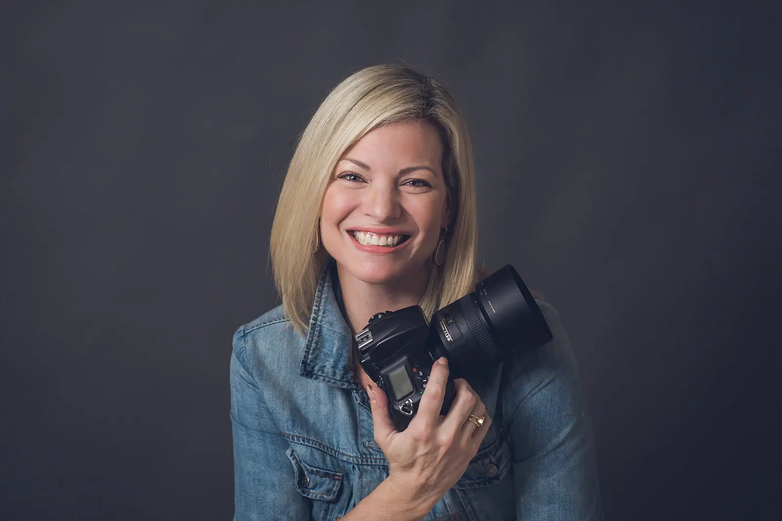 A woman with shoulder-length blonde hair smiles warmly at the camera